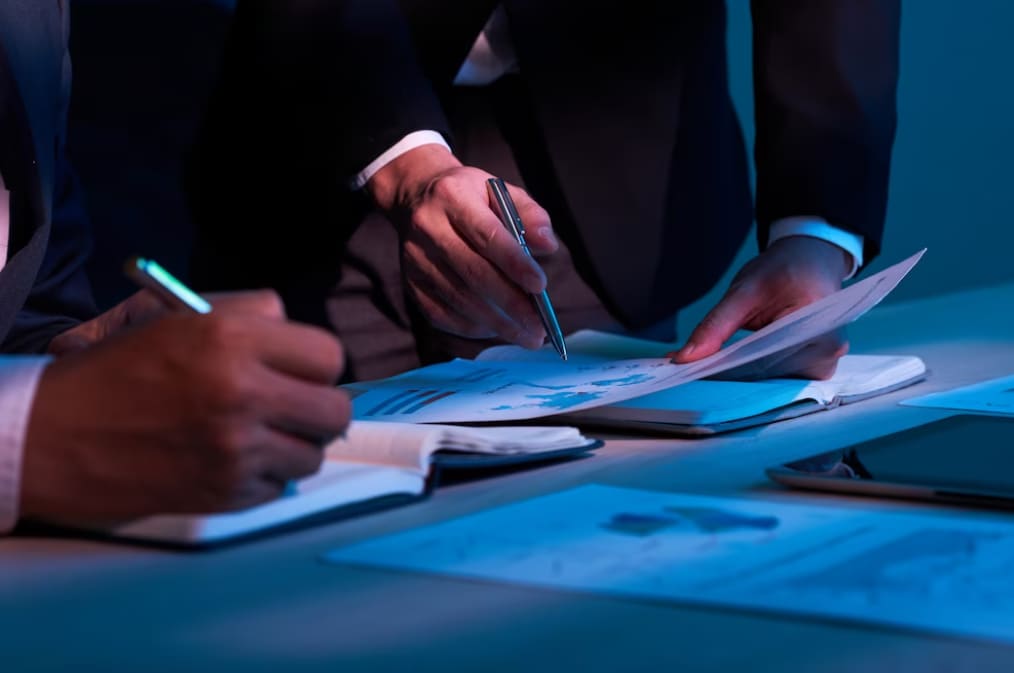 Businesspeople analyzing documents with glowing financial graphs